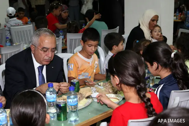Palestinian Prime Minister, Salam Fayyad during his participation Orphans of the Orphan Care Charitable Society the meal of "Iftar" in the month of Ramadan in the West Bank city of Bethlehem on Aug. 11, 2011. Photo by Mu...