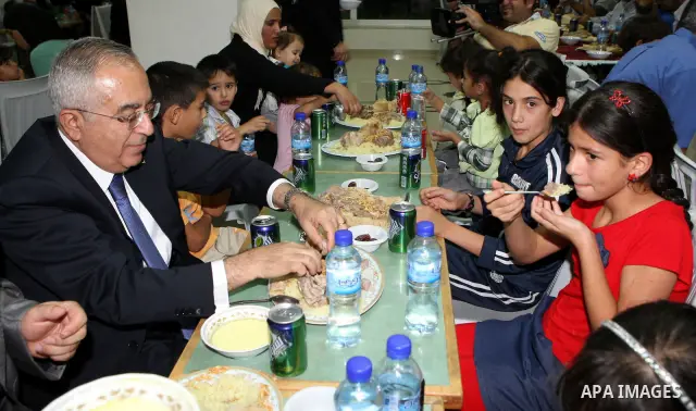 Palestinian Prime Minister, Salam Fayyad during his participation Orphans of the Orphan Care Charitable Society the meal of "Iftar" in the month of Ramadan in the West Bank city of Bethlehem on Aug. 11, 2011. Photo by Mu...