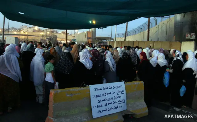 Palestinian women wait in line to pass through the Kalandia checkpoint from the West Bank town of Ramallah to Jerusalem, 12 August 2011, to attend the second Friday prayers in the Muslim holy month of Ramadan at al-Aqsa...