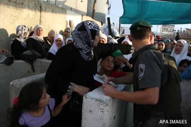 Palestinian women wait in line to pass through the Kalandia checkpoint from the West Bank town of Ramallah to Jerusalem, 12 August 2011, to attend the second Friday prayers in the Muslim holy month of Ramadan at al-Aqsa...
