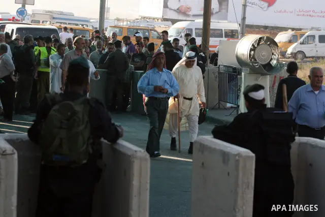 Palestinians wait in line to pass through the Kalandia checkpoint from the West Bank town of Ramallah to Jerusalem, 12 August 2011, to attend the second Friday prayers in the Muslim holy month of Ramadan at al-Aqsa mosqu...