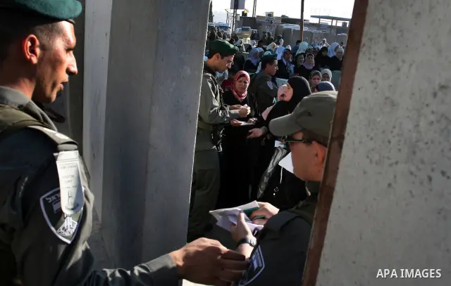 Palestinian women wait in line to pass through the Kalandia checkpoint from the West Bank town of Ramallah to Jerusalem, 12 August 2011, to attend the second Friday prayers in the Muslim holy month of Ramadan at al-Aqsa...