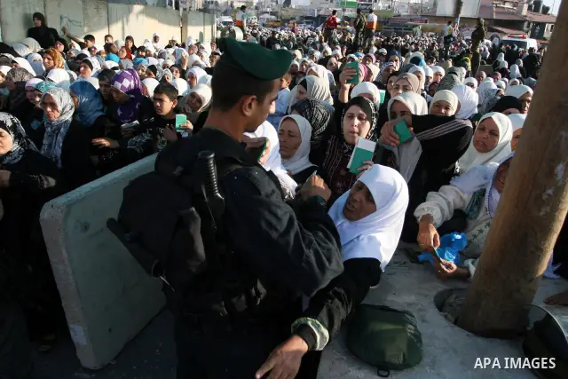 Palestinian women wait in line to pass through the Kalandia checkpoint from the West Bank town of Ramallah to Jerusalem, 12 August 2011, to attend the second Friday prayers in the Muslim holy month of Ramadan at al-Aqsa...