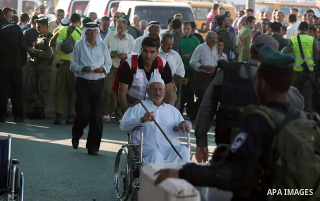 Palestinians wait in line to pass through the Kalandia checkpoint from the West Bank town of Ramallah to Jerusalem, 12 August 2011, to attend the second Friday prayers in the Muslim holy month of Ramadan at al-Aqsa mosqu...