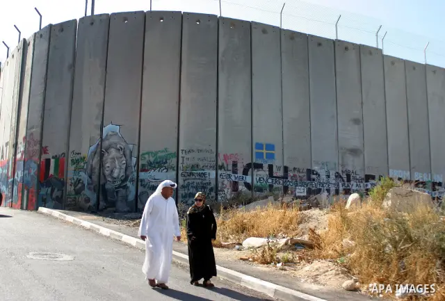 Palestinian Muslims walk through an Israeli checkpoint on the outskirts of the West Bank city of Bethlehem on August 12, 2011 as they wait to cross into Jerusalem to attend the second Friday prayers of the holy fasting m...