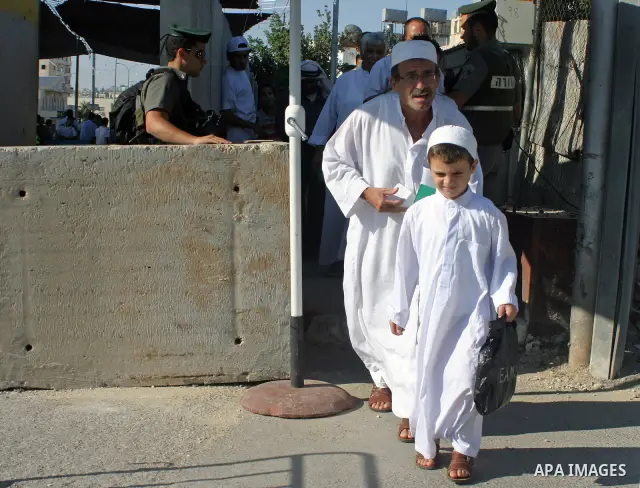 Palestinian Muslims walk through an Israeli checkpoint on the outskirts of the West Bank city of Bethlehem on August 12, 2011 as they wait to cross into Jerusalem to attend the second Friday prayers of the holy fasting m...