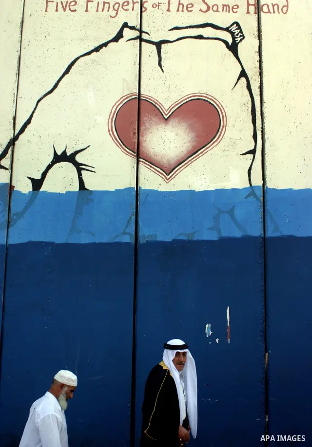 Palestinian Muslims walk through an Israeli checkpoint on the outskirts of the West Bank city of Bethlehem on August 12, 2011 as they wait to cross into Jerusalem to attend the second Friday prayers of the holy fasting m...