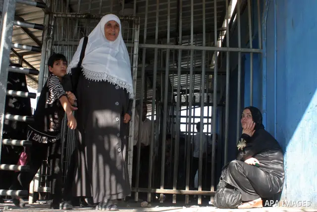 Palestinian Muslims walk through an Israeli checkpoint on the outskirts of the West Bank city of Bethlehem on August 12, 2011 as they wait to cross into Jerusalem to attend the second Friday prayers of the holy fasting m...