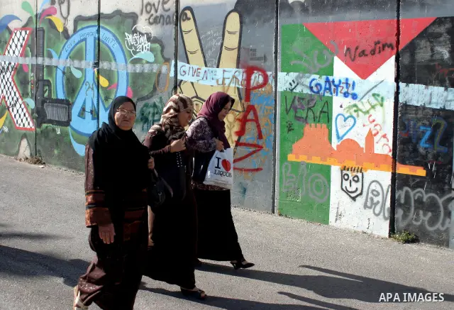 Palestinian Muslims walk through an Israeli checkpoint on the outskirts of the West Bank city of Bethlehem on August 12, 2011 as they wait to cross into Jerusalem to attend the second Friday prayers of the holy fasting m...