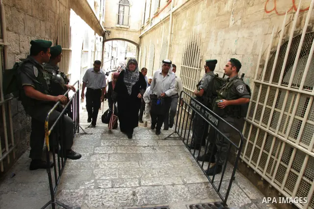 Israeli soldiers watch over Palestinians as they go to the Al Aqsa Mosque in Jerusalem, on the second Friday of the Muslim holy month of Ramadan, Friday Aug. 12, 2011. Muslims around the world are observing the holy fast...