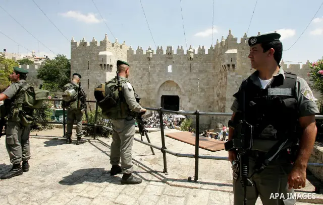 Israeli soldiers watch over Palestinians as they go to the Al Aqsa Mosque in Jerusalem, on the second Friday of the Muslim holy month of Ramadan, Friday Aug. 12, 2011. Muslims around the world are observing the holy fast...