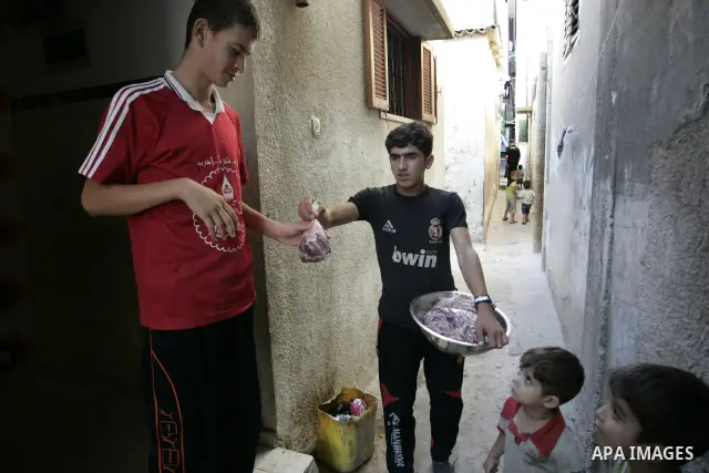 A Palestinian boy participates in the distribution of meat on the homes of the poor and needy on the thirteenth day at the occasion of the holy fasting month of Ramadan in Rafah, southern Gaza Strip on Aug. 13, 2011. whe...