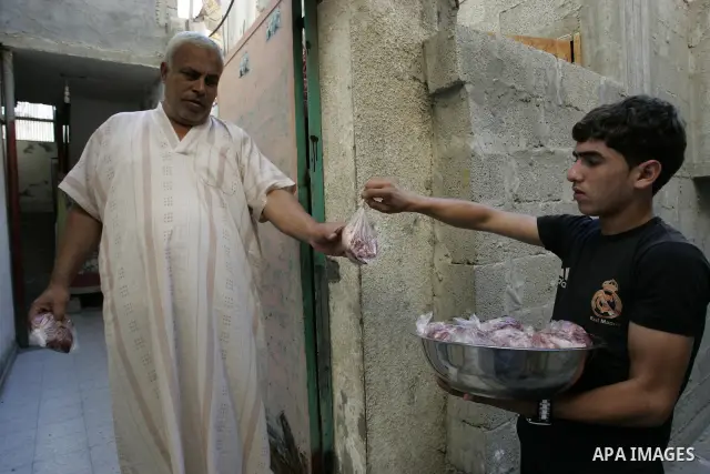 A Palestinian boy participates in the distribution of meat on the homes of the poor and needy on the thirteenth day at the occasion of the holy fasting month of Ramadan in Rafah, southern Gaza Strip on Aug. 13, 2011. whe...