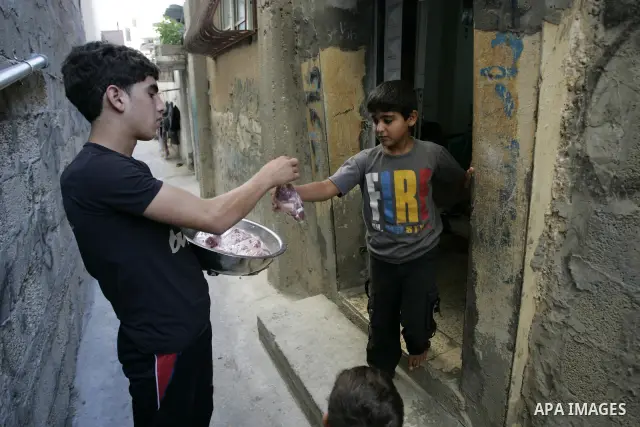 A Palestinian boy participates in the distribution of meat on the homes of the poor and needy on the thirteenth day at the occasion of the holy fasting month of Ramadan in Rafah, southern Gaza Strip on Aug. 13, 2011. whe...
