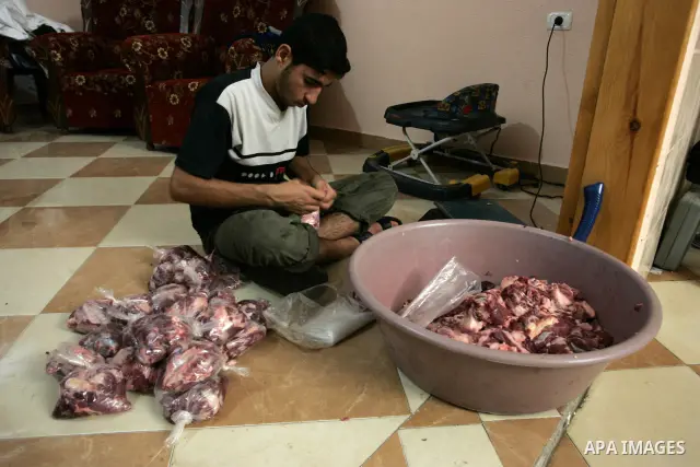Palestinian slaughters a calf on the thirteenth day of the Moslem holy month of Ramadan in Rafah, southern Gaza Strip on Aug. 13, 2011. The meat will be distributed to the needy and poor on the occasion of the holy fasti...