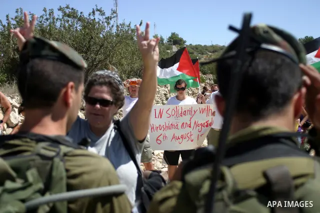 Israeli soldiers scuffle with Palestinian, Israeli and foreign activists during a demonstration against the cof farm land to be used in the construction of Jewish settlements near the existing Israeli settlement of Karmi...