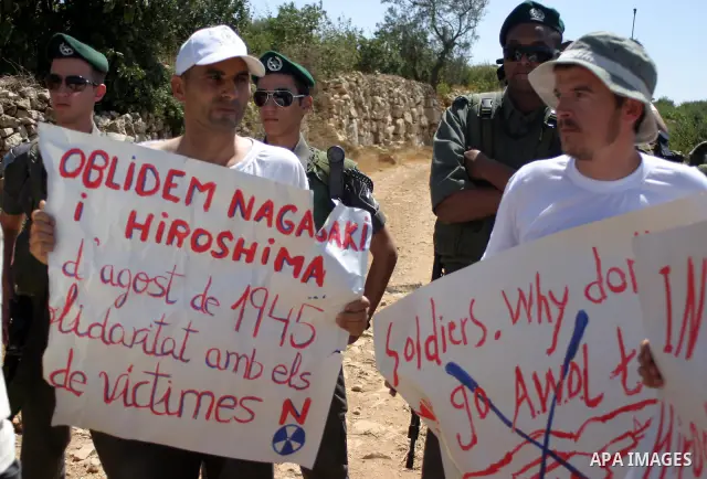Israeli soldiers scuffle with Palestinian, Israeli and foreign activists during a demonstration against the cof farm land to be used in the construction of Jewish settlements near the existing Israeli settlement of Karmi...
