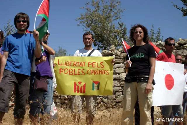 Israeli soldiers scuffle with Palestinian, Israeli and foreign activists during a demonstration against the cof farm land to be used in the construction of Jewish settlements near the existing Israeli settlement of Karmi...