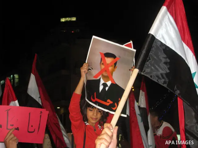 Palestinians hold Syrian flags as they join a demonstration in the West Bank city of Ramallah on Aug. 14, 2011 in support of the Syrian opposition . At least 23 people were killed 14 August when the Syrian army attacked...