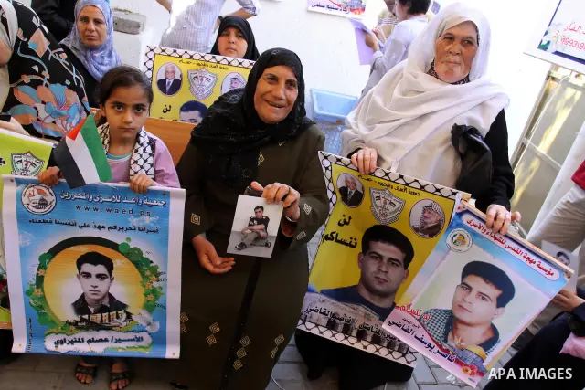 Palestinian women hold pictures of their prisoned relatives in Israeli jails as they gather in a weekly activity calling for their liberty at the Red Cross headquarters in Gaza City on Aug.15, 2011. About 7000 prisoners...