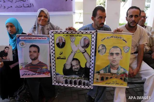 Palestinians hold pictures of their prisoned relatives in Israeli jails as they gather in a weekly activity calling for their liberty at the Red Cross headquarters in Gaza City on Aug.15, 2011. About 7000 prisoners are i...