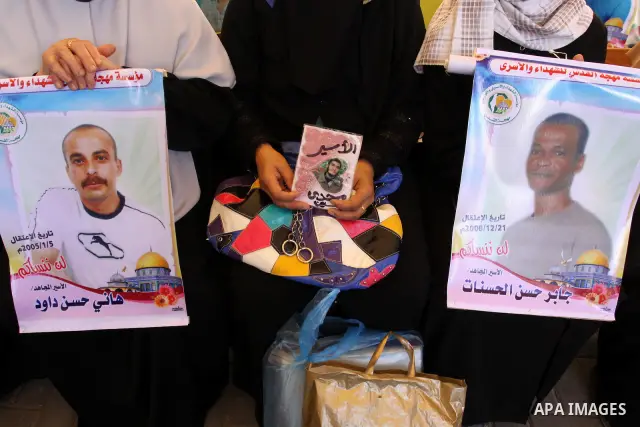 Palestinians hold pictures of their prisoned relatives in Israeli jails as they gather in a weekly activity calling for their liberty at the Red Cross headquarters in Gaza City on Aug.15, 2011. About 7000 prisoners are i...