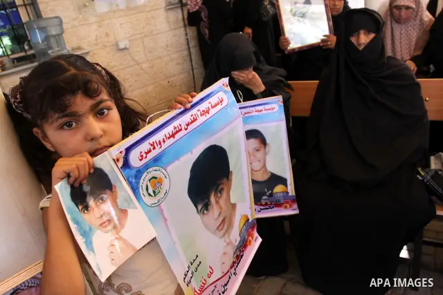 Palestinians hold pictures of their prisoned relatives in Israeli jails as they gather in a weekly activity calling for their liberty at the Red Cross headquarters in Gaza City on Aug.15, 2011. About 7000 prisoners are i...