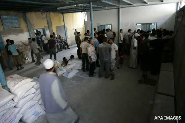 Palestinians receive food aids from the United Nations Relief and Works Agency (UNRWA) at the Rafah refugee camp, in the southern Gaza Strip on August 15, 2011. USAID halted humanitarian assistance to the Gaza Strip over...