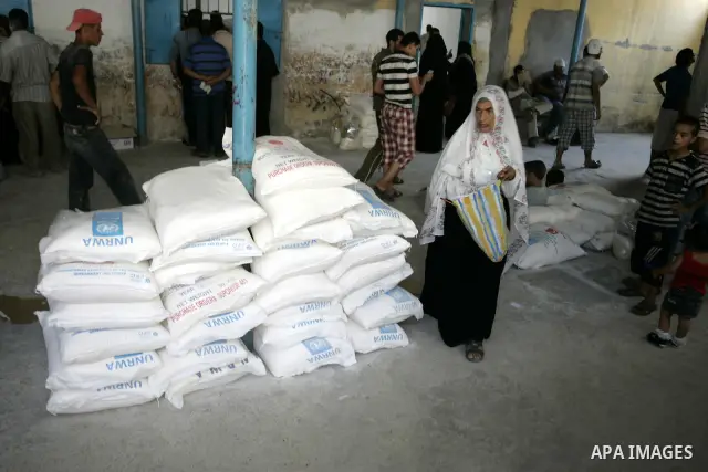 Palestinians receive food aids from the United Nations Relief and Works Agency (UNRWA) at the Rafah refugee camp, in the southern Gaza Strip on August 15, 2011. USAID halted humanitarian assistance to the Gaza Strip over...