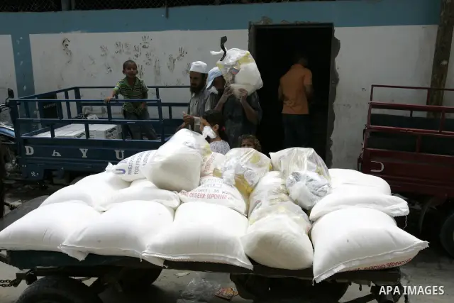 Palestinians receive food aids from the United Nations Relief and Works Agency (UNRWA) at the Rafah refugee camp, in the southern Gaza Strip on August 15, 2011. USAID halted humanitarian assistance to the Gaza Strip over...