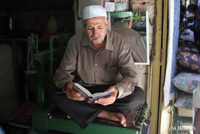 A Palestinian vendor reads the holy koran infront of his shop in the West Bank city of Hebron on Aug. 15, 2011. Muslims around the world abstain from eating, drinking and conducting sexual relations from sunrise to sunse...