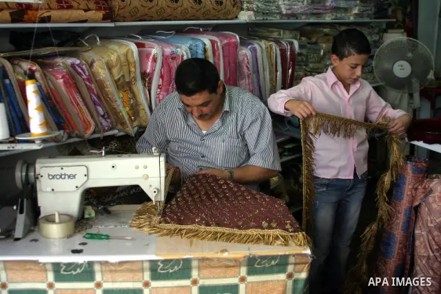 A Palestinian vendor sells cloth at a shop in the West Bank city of Hebron on Aug. 15, 2011. Muslims around the world abstain from eating, drinking and conducting sexual relations from sunrise to sunset during Ramadan, t...