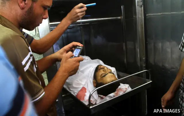 Palestinian relatives stand next to the body of Hamas militant Moussa Shtewi, 29, at the morgue in a hospital in Gaza City, Tuesday, on Aug. 16, 2011. Israeli aircraft struck five targets in the Hamas-ruled Gaza Strip on...