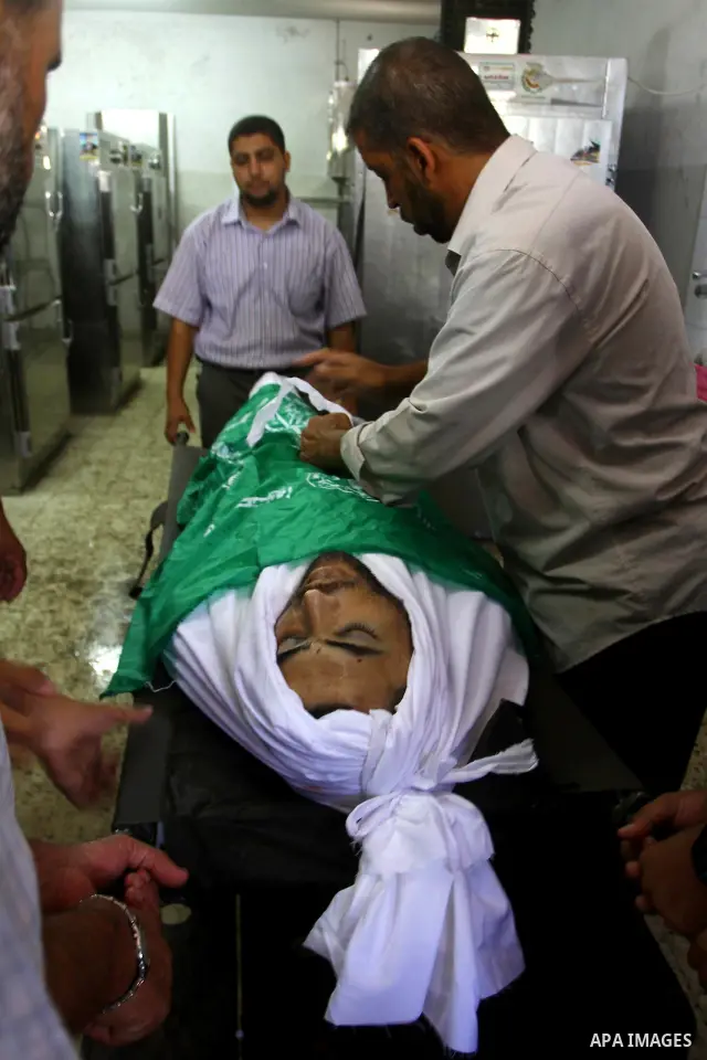 Palestinian relatives stand next to the body of Hamas militant Moussa Shtewi, 29, at the morgue in a hospital in Gaza City, Tuesday, on Aug. 16, 2011. Israeli aircraft struck five targets in the Hamas-ruled Gaza Strip on...