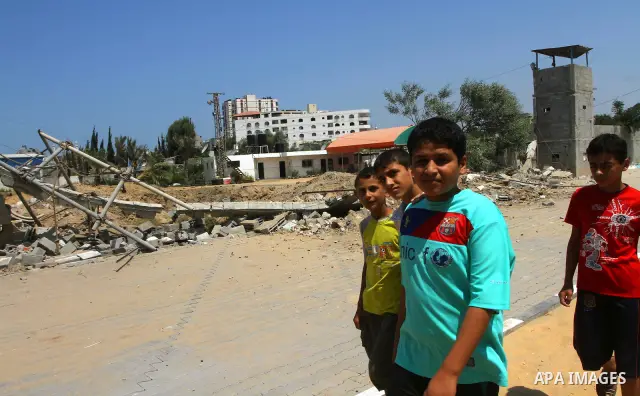 Palestinian children stand at the site of an Israeli air strike in Gaza City on August 16, 2011 after one Palestinian was killed and seven injured by overnight Israeli air strikes across the Gaza Strip, Palestinian medic...
