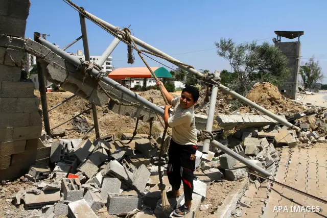 Palestinian children stand at the site of an Israeli air strike in Gaza City on August 16, 2011 after one Palestinian was killed and seven injured by overnight Israeli air strikes across the Gaza Strip, Palestinian medic...