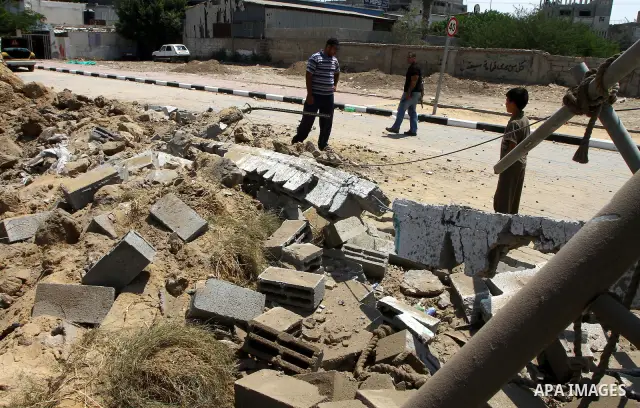 Palestinian children stand at the site of an Israeli air strike in Gaza City on August 16, 2011 after one Palestinian was killed and seven injured by overnight Israeli air strikes across the Gaza Strip, Palestinian medic...