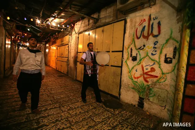 Palestinian youths use a traditional drum to wake up people for their Suhoor in a narrow street leading to the al-Aqsa Mosque in Jerusalem's Old City on August 16,2011, during the sixteenth day of the Muslim holy month o...