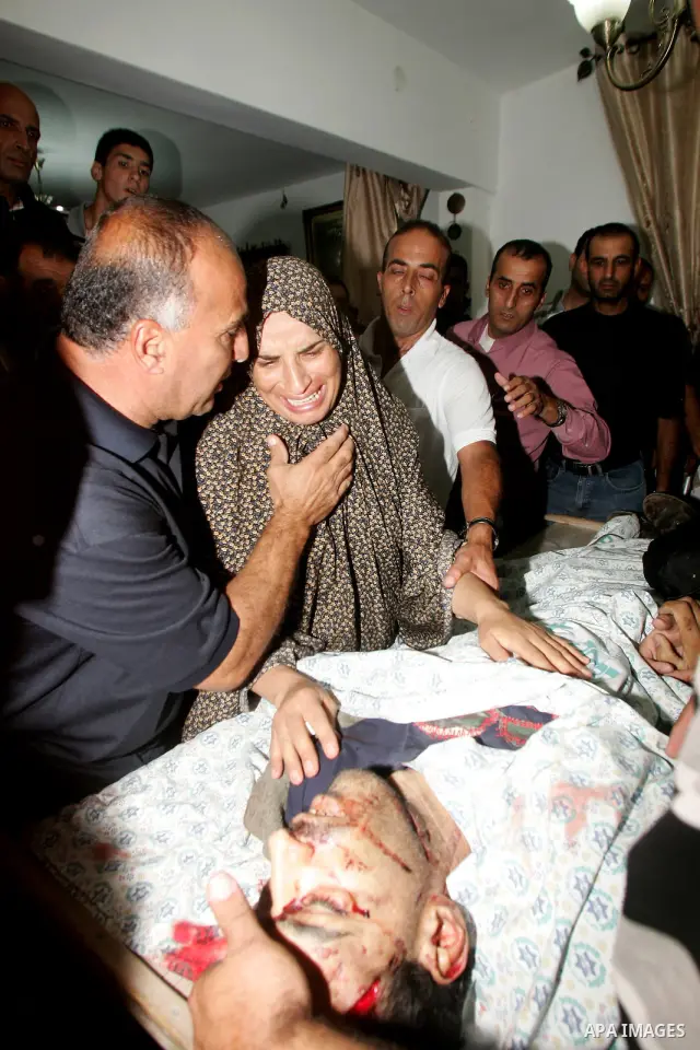 Relatives of the Palestinian Amin Taleb Dabash, 32, mourn over his body during his funeral in the village of Sur Baher in east Jerusalem on August 17,2011. Dabash was killed after an Israeli military jeep hit him . Photo...