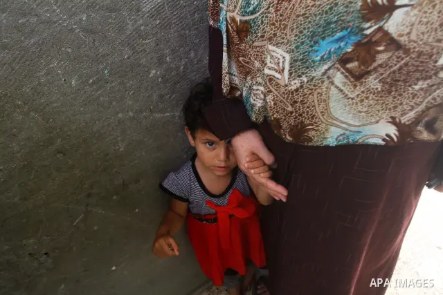 Palestinian girl stands with her mother during the funeral of Saed al Majdalawai in Nusseirat refugee camp in the central Gaza Strip on August 17, 2011. Israeli forces shot dead al Majdalawai near the border fence with I...