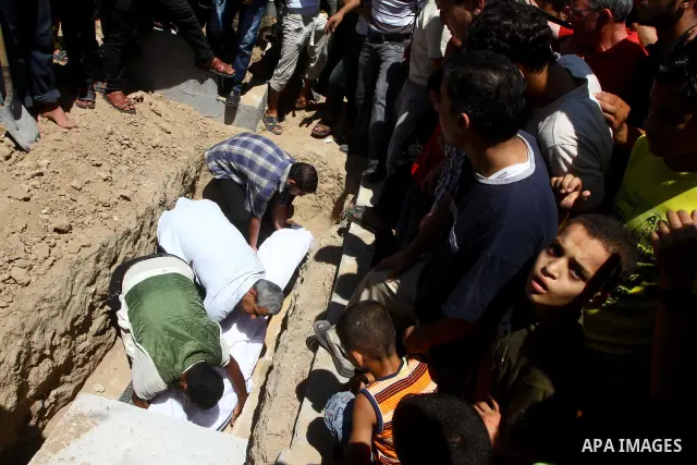 Palestinian mourners bury the body of Saad al-Majdalali before his funeral in the central Gaza Strip refugee camp of Nusseirat on August 17, 2011 a day after Israeli troops shot and killed him as he came near to the bord...