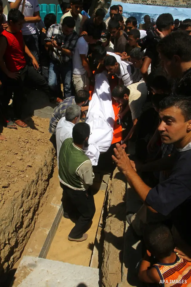 Palestinian mourners carry the body of Saed al Majdalawa during his funeral in the central Gaza Strip refugee camp of Nusseirat on August 17, 2011 a day after Israeli troops shot and killed him as he came near to the bor...