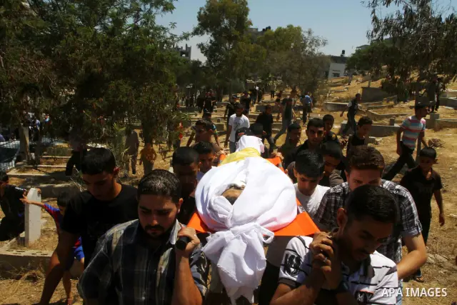 Palestinian mourners carry the body of Saed al Majdalawa during his funeral in the central Gaza Strip refugee camp of Nusseirat on August 17, 2011 a day after Israeli troops shot and killed him as he came near to the bor...