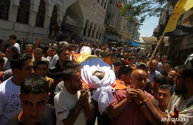Palestinian mourners carry the body of Saed al Majdalawa during his funeral in the central Gaza Strip refugee camp of Nusseirat on August 17, 2011 a day after Israeli troops shot and killed him as he came near to the bor...