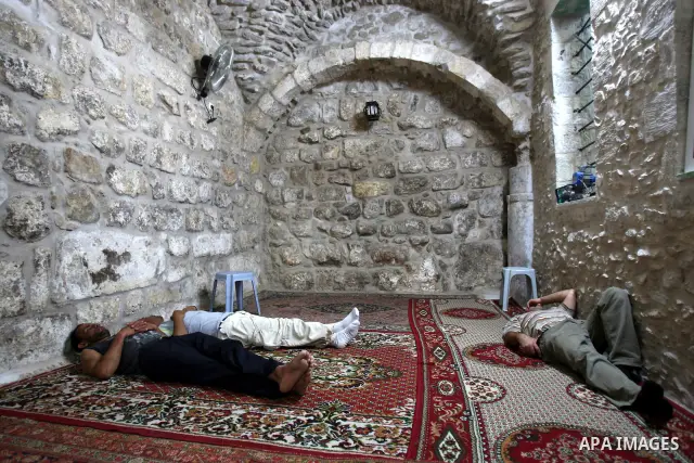 Palestinian Muslims rest as others pray and read the holy Koran at a Mosque during the holy month of Ramadan in the West Bank city of Nablus on Aug. 17, 2011. Muslims around the world are observing the holy fasting month...