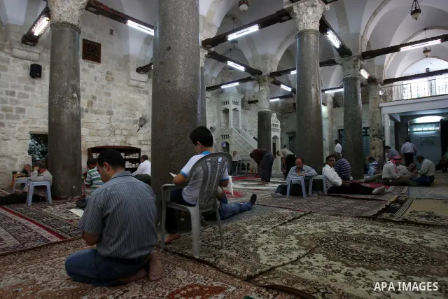Palestinian Muslims rest as others pray and read the holy Koran at a Mosque during the holy month of Ramadan in the West Bank city of Nablus on Aug. 17, 2011. Muslims around the world are observing the holy fasting month...