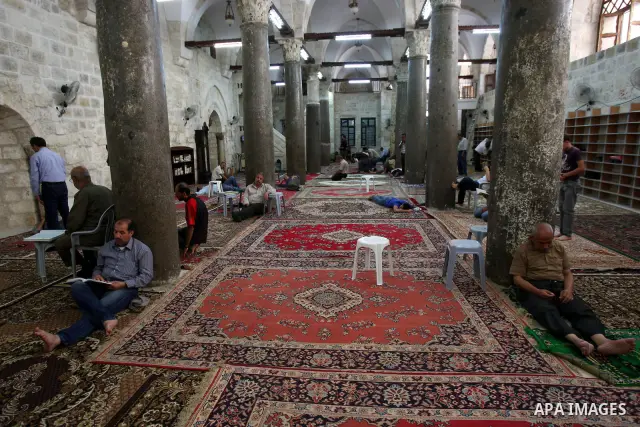 Palestinian Muslims rest as others pray and read the holy Koran at a Mosque during the holy month of Ramadan in the West Bank city of Nablus on Aug. 17, 2011. Muslims around the world are observing the holy fasting month...