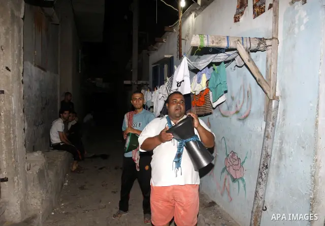 Palestinian youths use a traditional drum to wake up people for their Suhoor in a narrow street in Gaza city on August 16, 2011, during the sixteenth day of the Muslim holy month of Ramadan. Photo by Mahmud Nassar