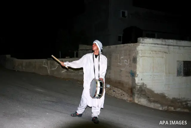 A Palestinian man 'Mesaharaty' uses a traditional drum to wake up people for their Suhoor, in the village of Balata in the West Bank city of Nablus, on, Aug .18, 2011. Muslims throughout the world are celebrating the hol...