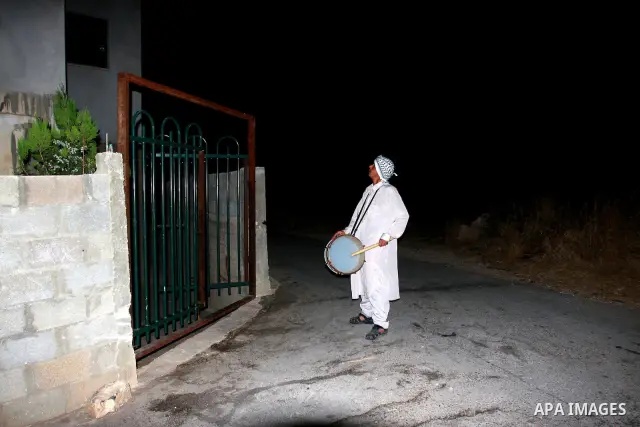 A Palestinian man 'Mesaharaty' uses a traditional drum to wake up people for their Suhoor, in the village of Balata in the West Bank city of Nablus, on, Aug .18, 2011. Muslims throughout the world are celebrating the hol...